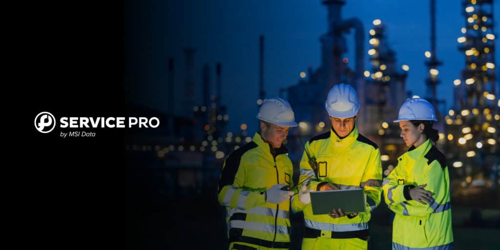 A technician in a hard hat and safety vest servicing industrial equipment on a manufacturing floor, representing enterprise field service management software.
