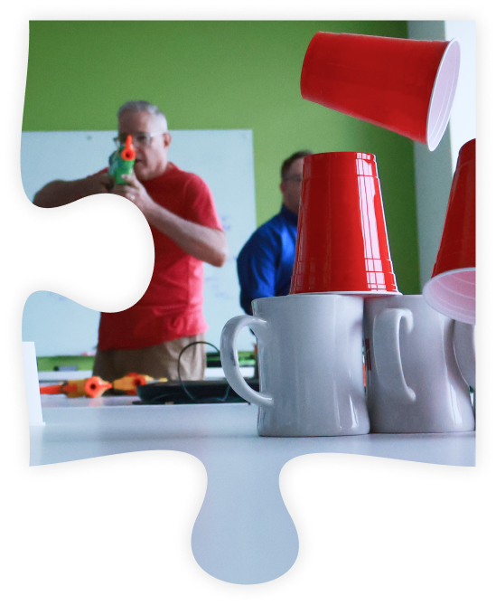 Puzzle piece with a photo of MSI Data employee shooting down cups.