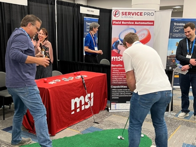 MSI Data employees playing mini golf at their trade show booth.