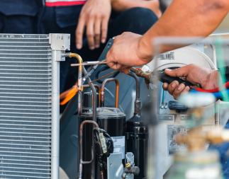 Close up image of field technician hands working with tools to fix mechanical equipment.